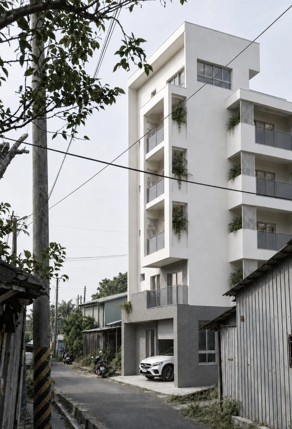 狹窄巷道中的白色多層住宅外觀與錯落植栽陽台
